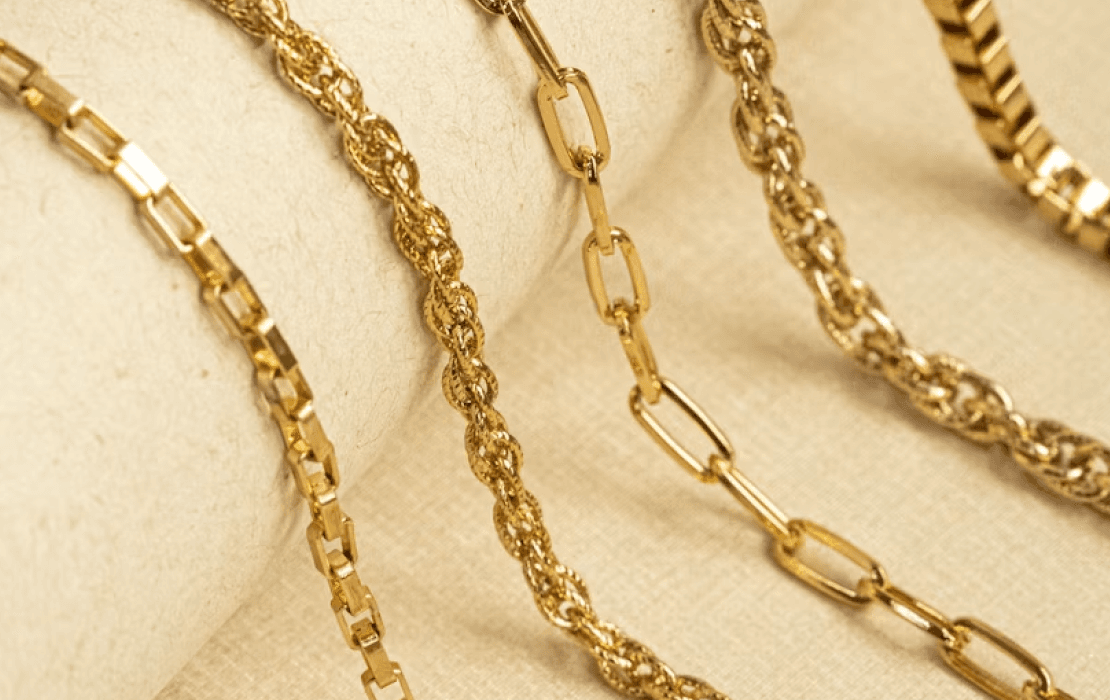 Gold chain bracelets arranged on linen