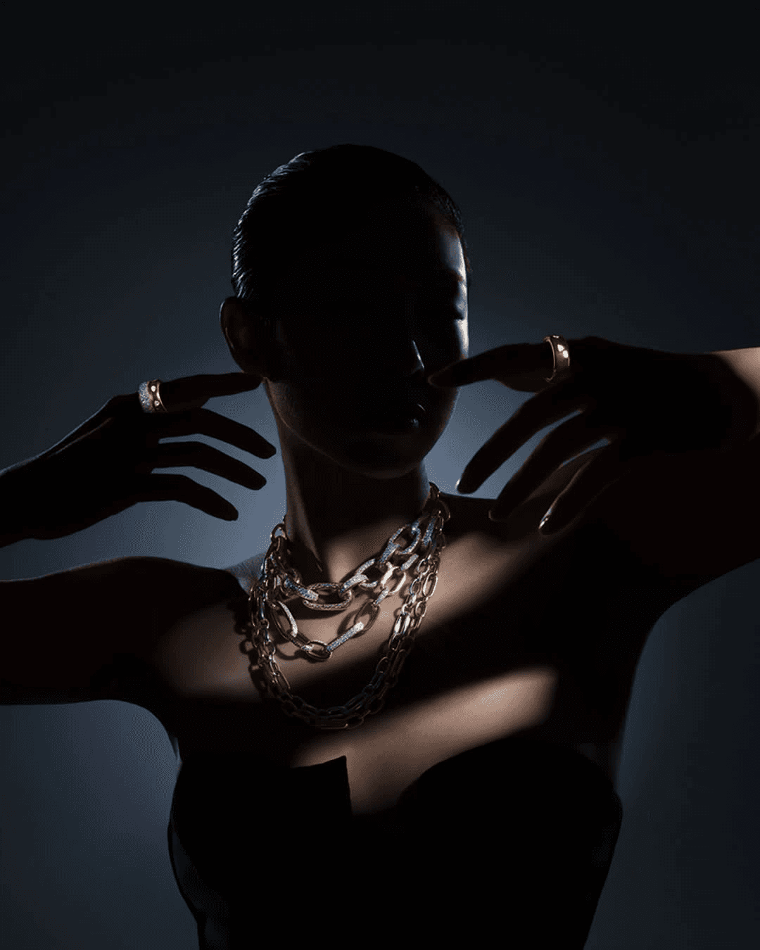 A woman wearing layered Diamond Soirée gold chains and rings